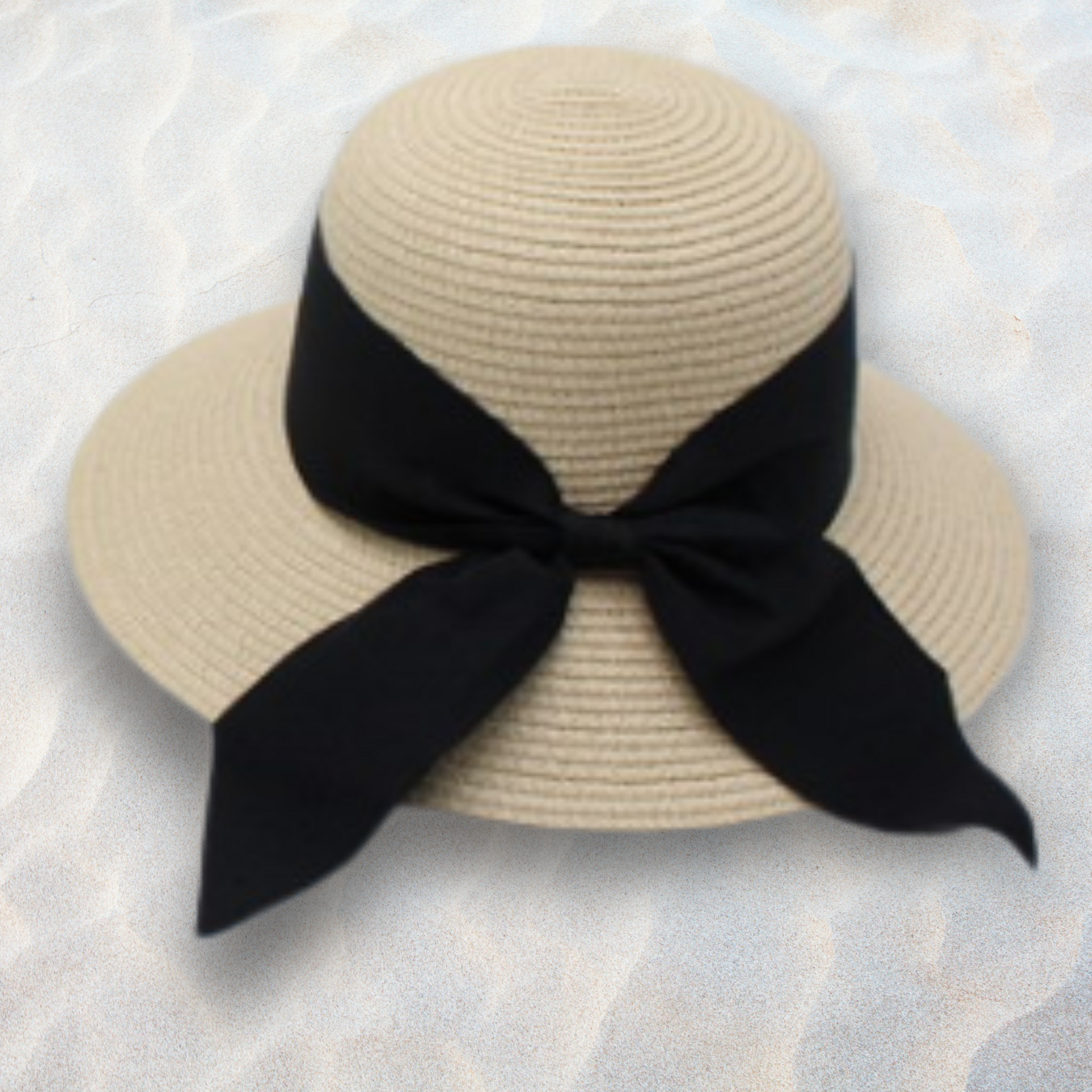 Beige straw hat with a black ribbon on a textured white background