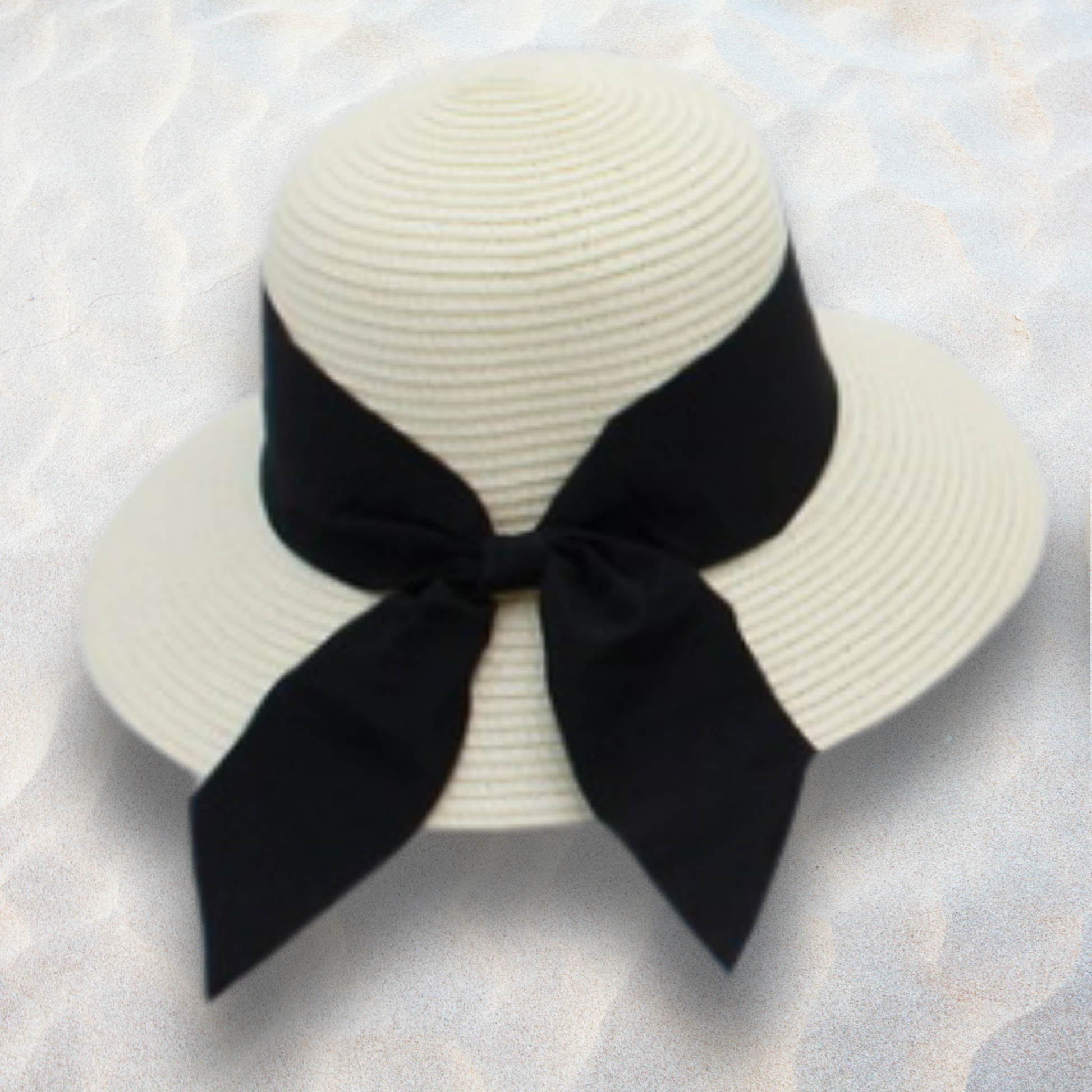 White straw hat with a black ribbon on a textured white background