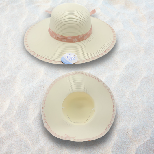 Two cream-colored sunhats with pink accents on a textured white surface.