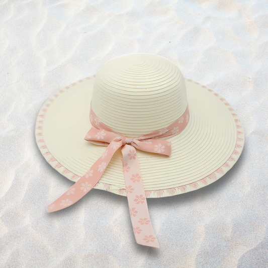 Beige sun hat with a pink floral ribbon on a light textured background