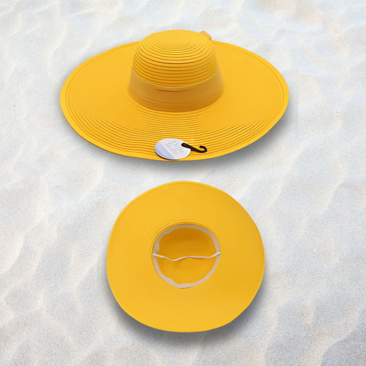 Two yellow sun hats on a textured white surface