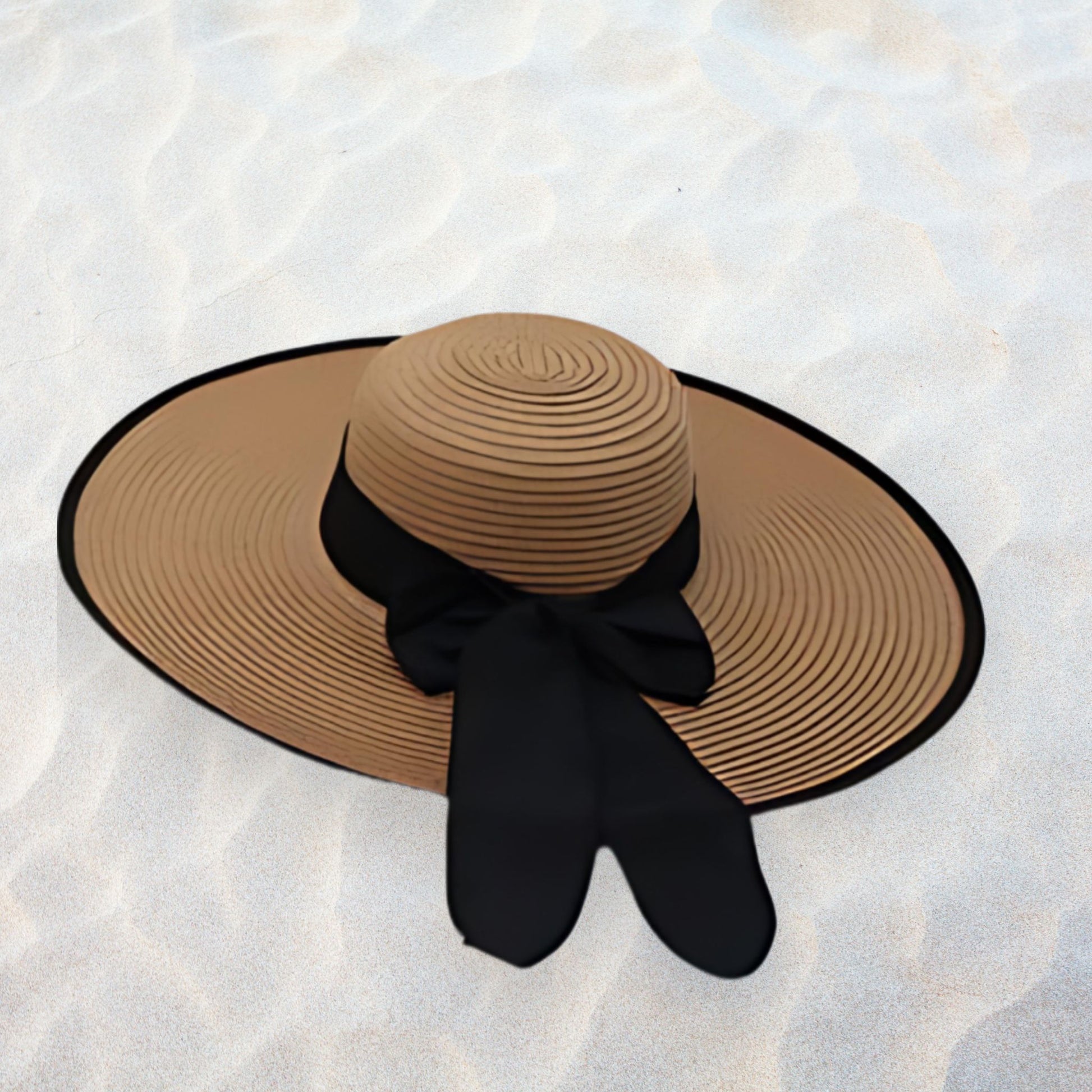 Brown sun hat with a black bow on a textured white surface