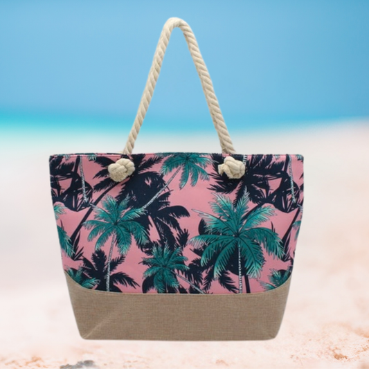 Tropical patterned beach bag with rope handles on a sandy background