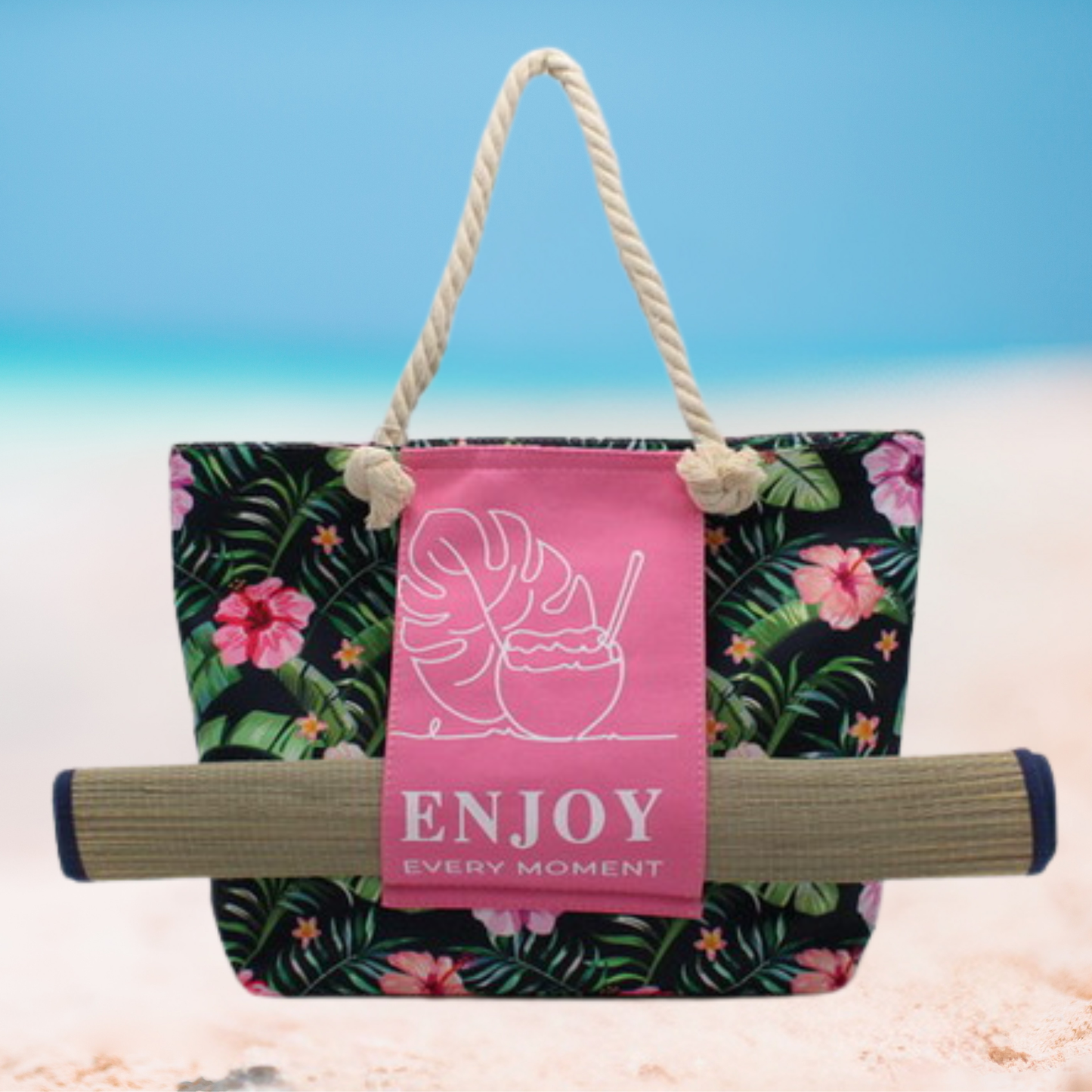 Large floral tote bag with thick rope handles, pink front panel featuring tropical leaf and coconut drink design with text ‘Enjoy Every Moment'