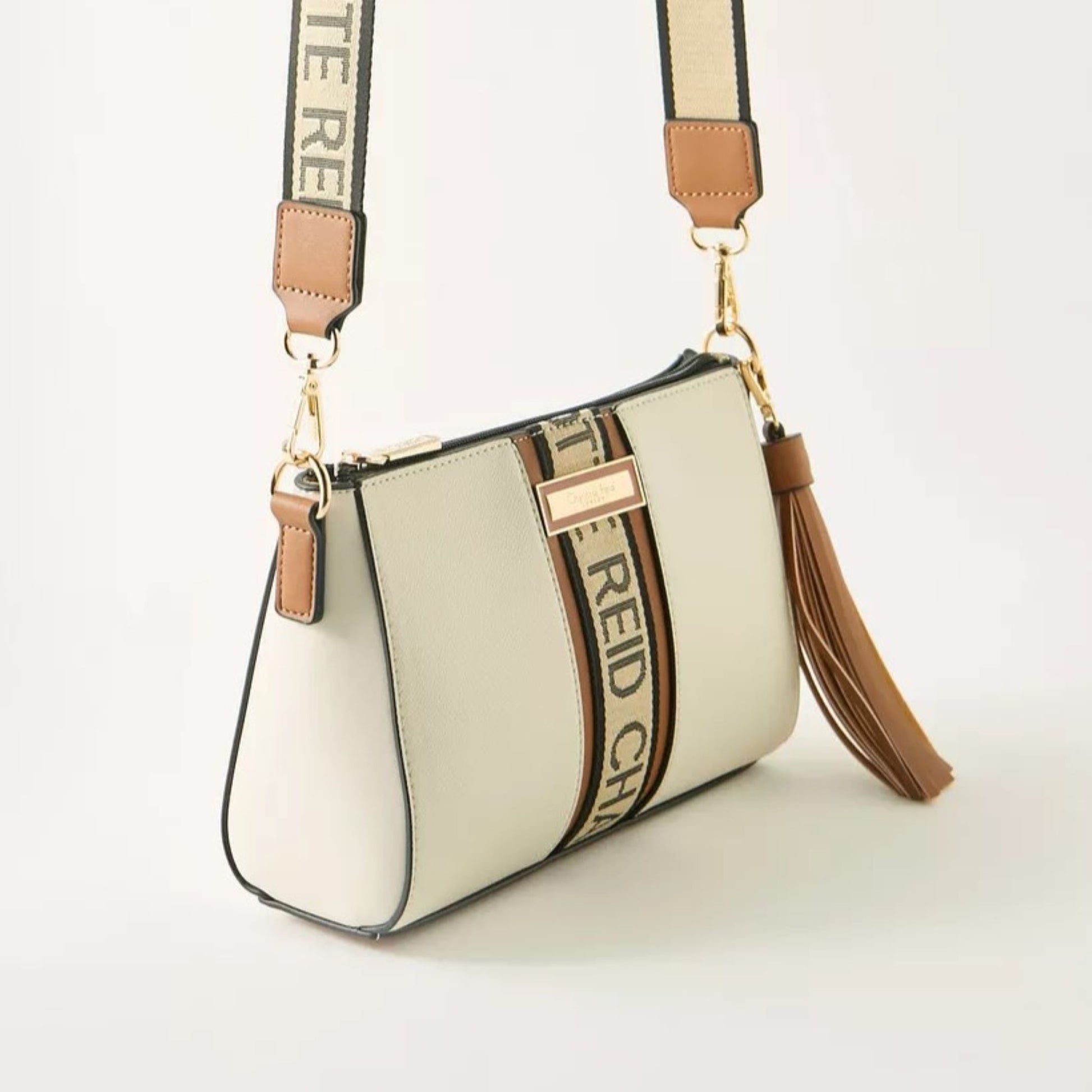 Beige pouch crossbody bag with removable and adjustable woven textured strap, with a monogram strip and removable tassel.