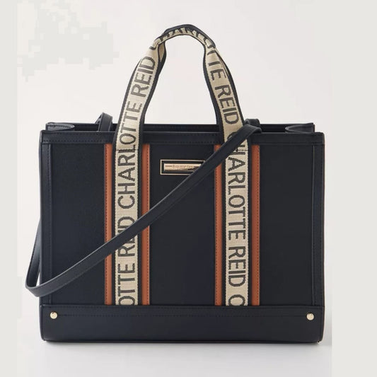 Black structured tote crossbody bag with long handles, contrast brown trim, top handles, adjustable shoulder strap, and spacious designer-inspired silhouette.