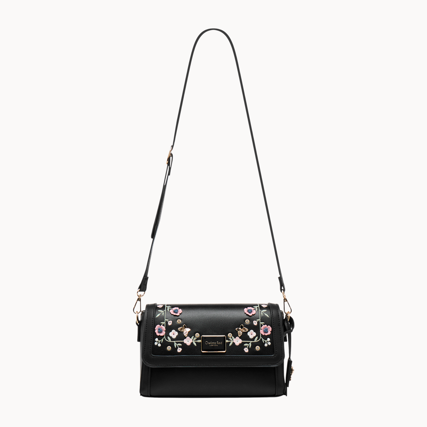 embroidered black floral crossbody bag in vegan leather. Features high-quality gold hardware & adjustable strap. Perfect for chic, everyday style.