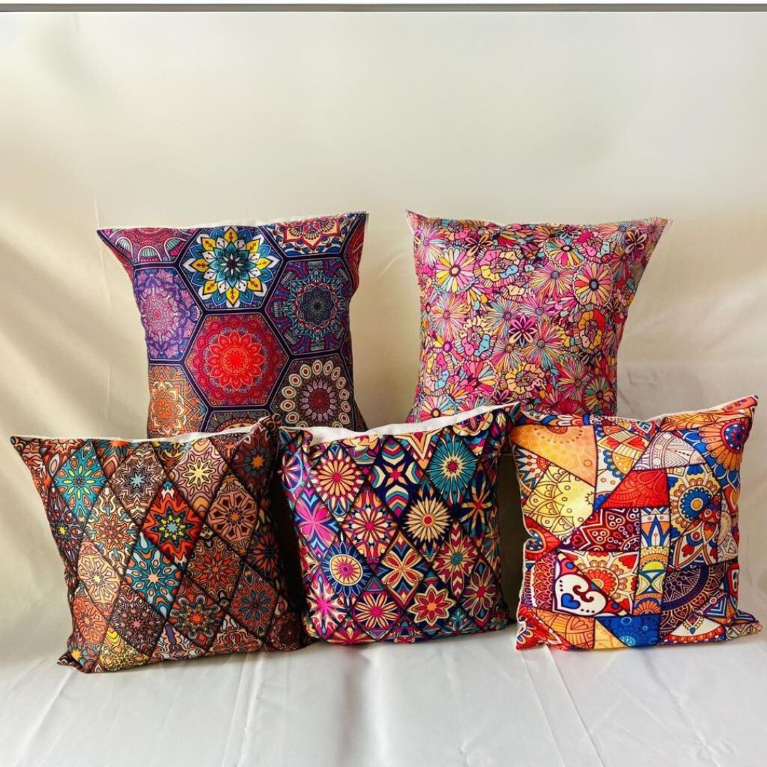A set of five square throw pillows with various colorful geometric and floral patterns.