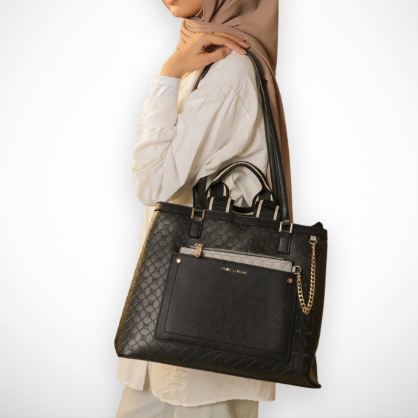 Person holding a black handbag with a gold chain detail against a white background