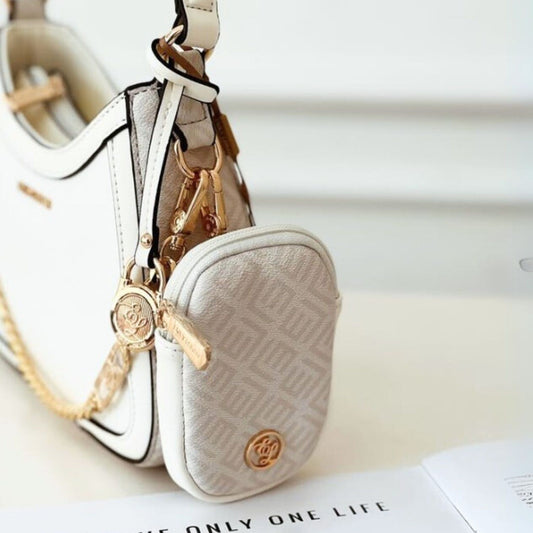 Small beige pouch with gold chain and keychain on a white surface