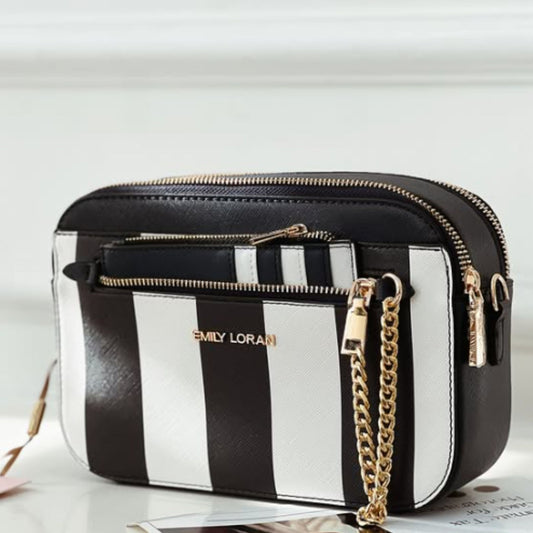 Navy and white striped handbag with gold chain on a light background