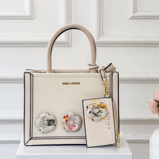 Beige handbag with floral design on a white surface