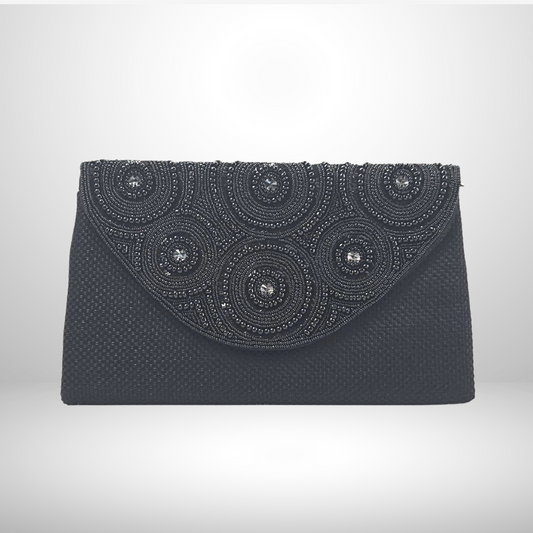 Black clutch bag with decorative circular patterns on a white background