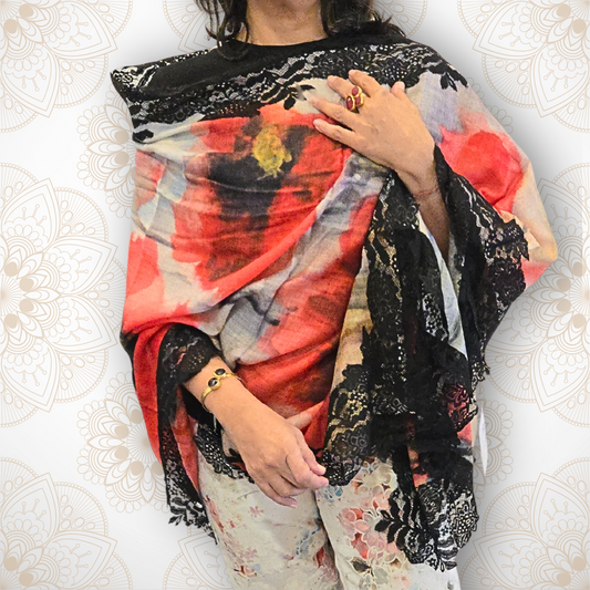 Person wearing a colorful scarf with black lace details on a white background