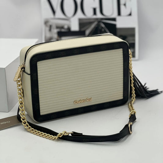 Cream crossbody camera bag with black trim and gold long chain