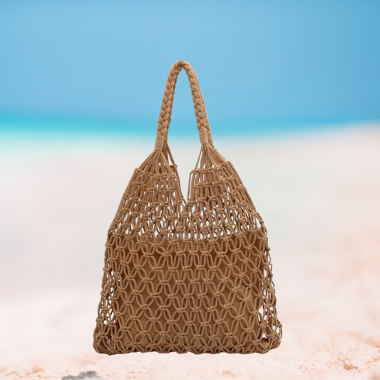 Woven brown bag on a beach with a blue sky background