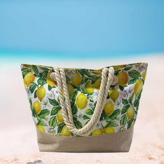Beach bag with lemon pattern and rope handles on a beach background