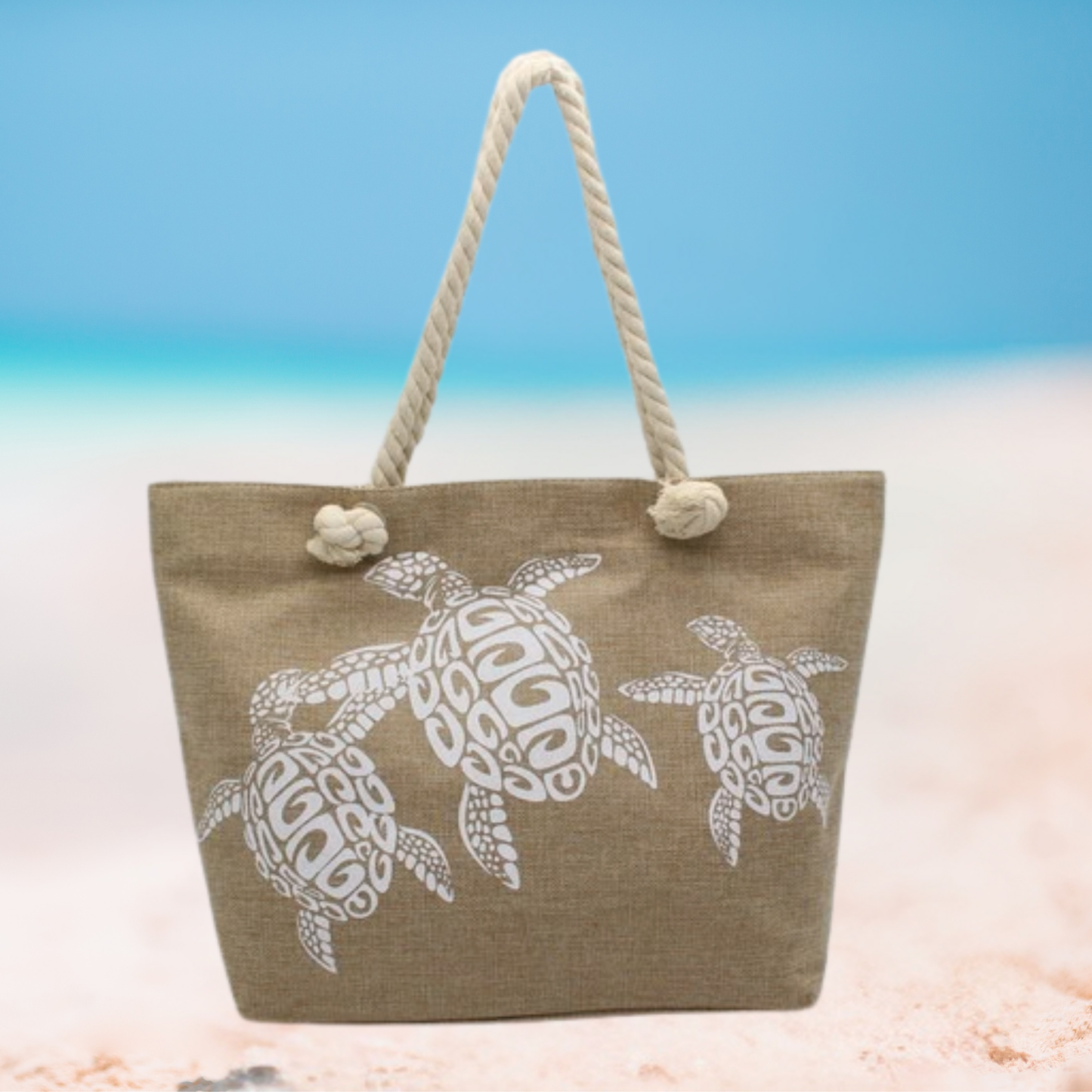 Beige tote bag with turtle design on a beach setting