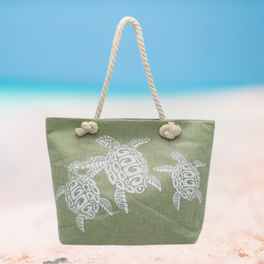 Green tote bag with white turtle design on a beach setting