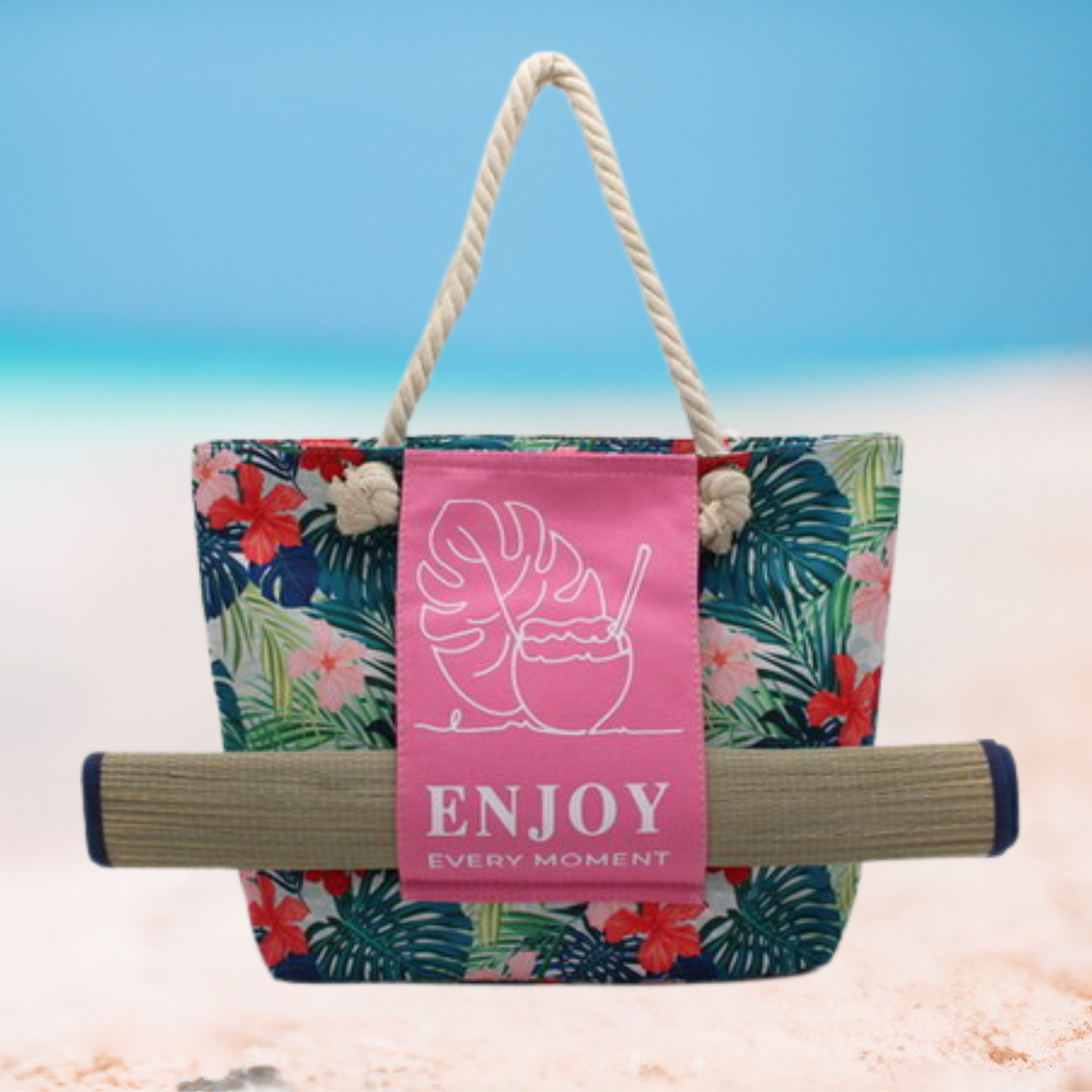 Large floral tote bag with thick rope handles, pink front panel featuring tropical leaf and coconut drink design with text ‘Enjoy Every Moment