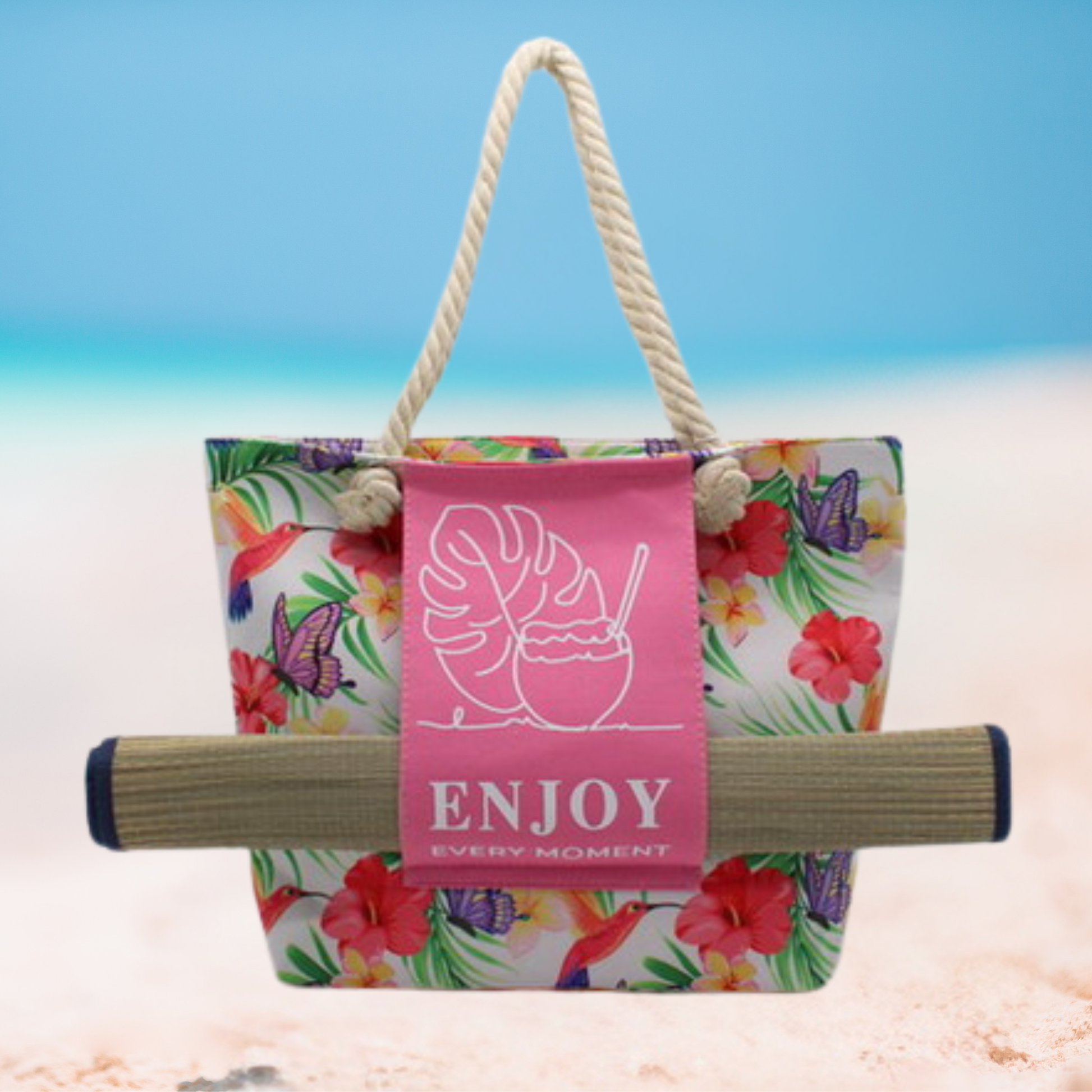 Large floral tote bag with thick rope handles, pink front panel featuring tropical leaf and coconut drink design with text ‘Enjoy Every Moment