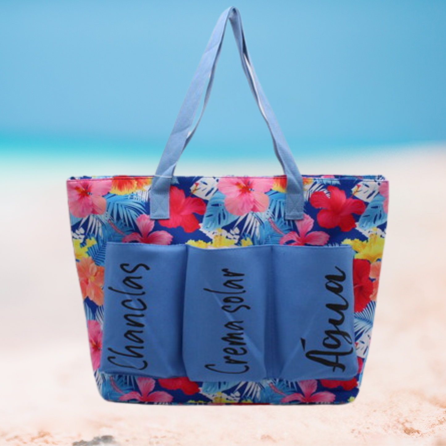 Large floral beach tote bag with labeled front pockets for flip-flops, sunscreen, and water, available in blue, yellow, and pink variations