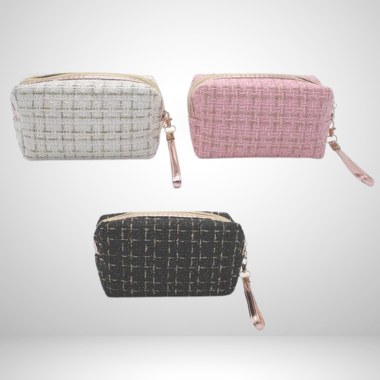 Refined tweed cosmetic bag with a luxe gold zipper and wrist strap. Compact for travel or daily use, keeping makeup secure. Available in pink, white, or black!