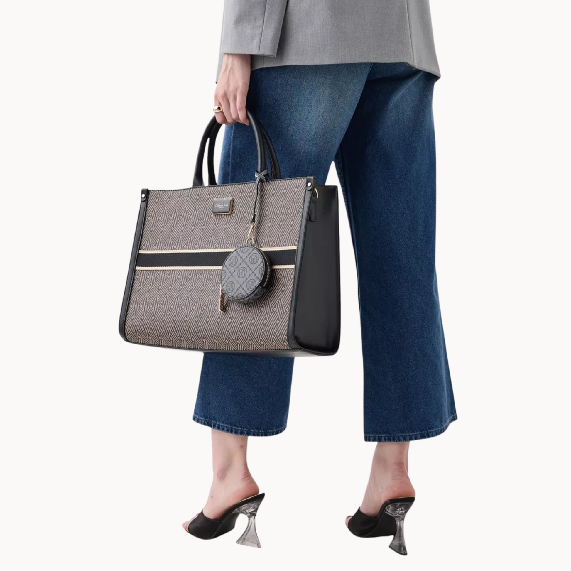 Person holding a gray handbag with a white background