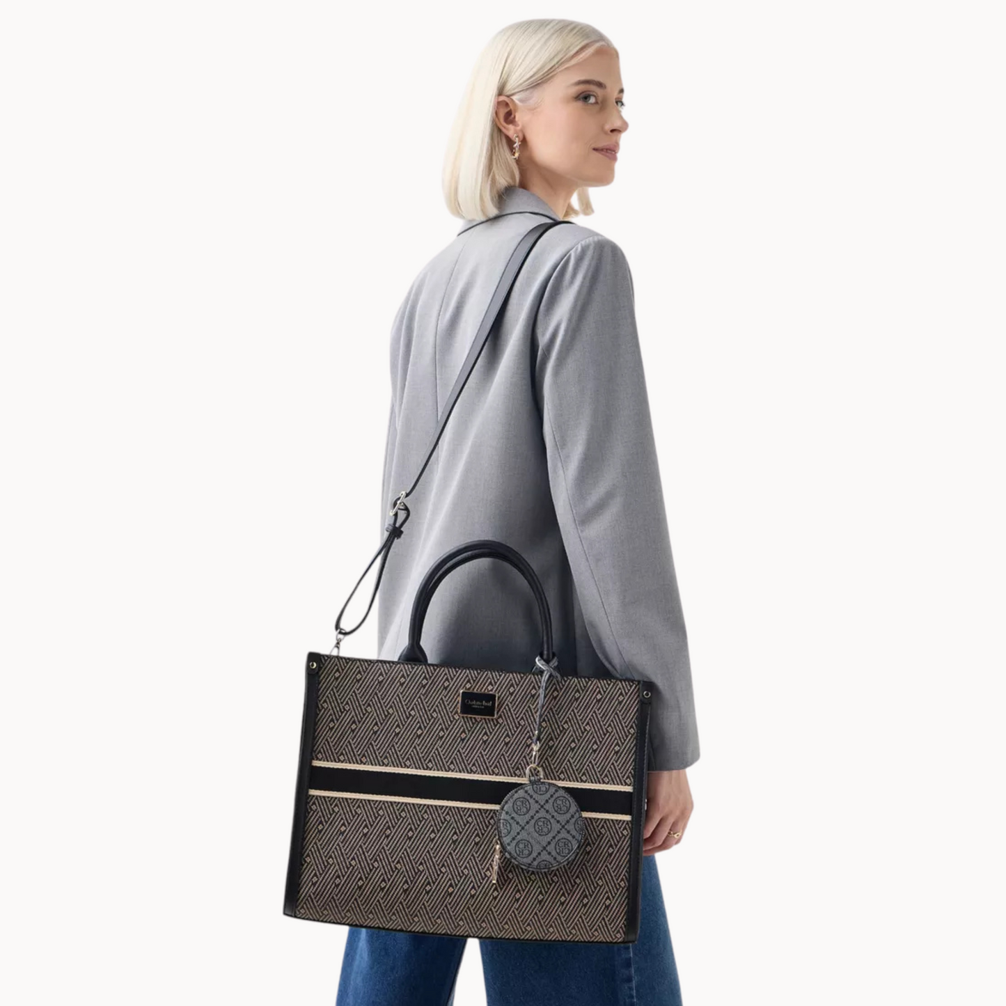 Woman carrying a black handbag with a visible brand logo on a white background