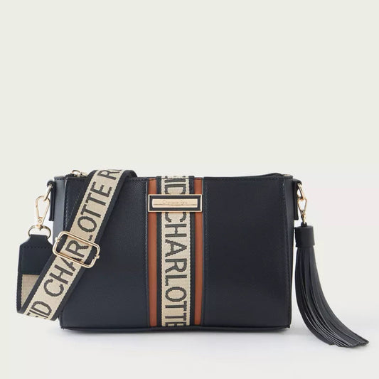Black handbag with a branded strap on a light beige background