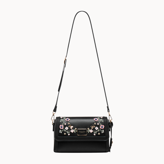 embroidered black floral crossbody bag in vegan leather. Features high-quality gold hardware & adjustable strap. Perfect for chic, everyday style.