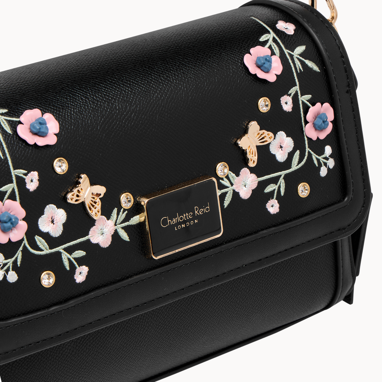embroidered black floral crossbody bag in vegan leather. Features high-quality gold hardware & adjustable strap. Perfect for chic, everyday style.