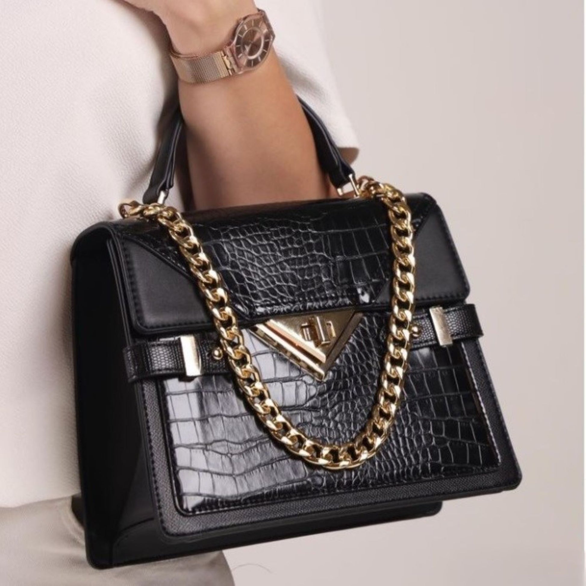 Small top handle handbag with mock croc patchwork on front and flap with chunky chain ornament with triangle gold turn lock and matching adjustable removable long strap.