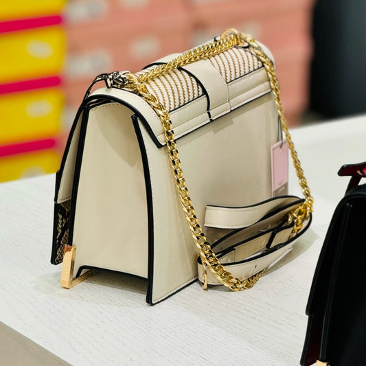 Beige handbag with gold chain strap on a white surface from InStyle Fashion HK.