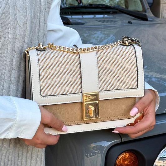 Beige handbag with gold accents held by a person in front of a car from InStyle Fashion HK.