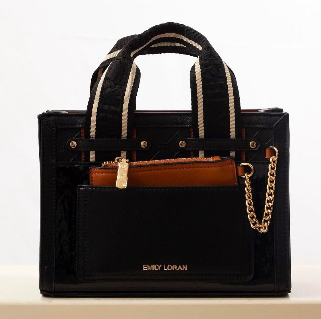 Black handbag with gold chain detail on a white background