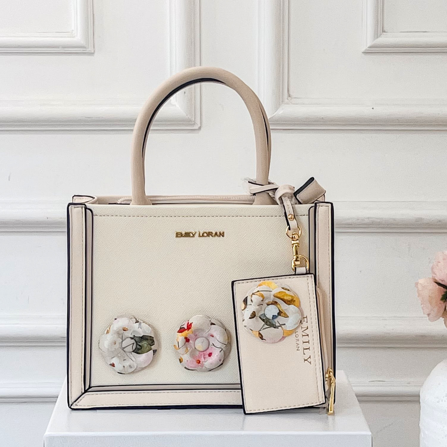 Beige handbag with floral design on a white surface