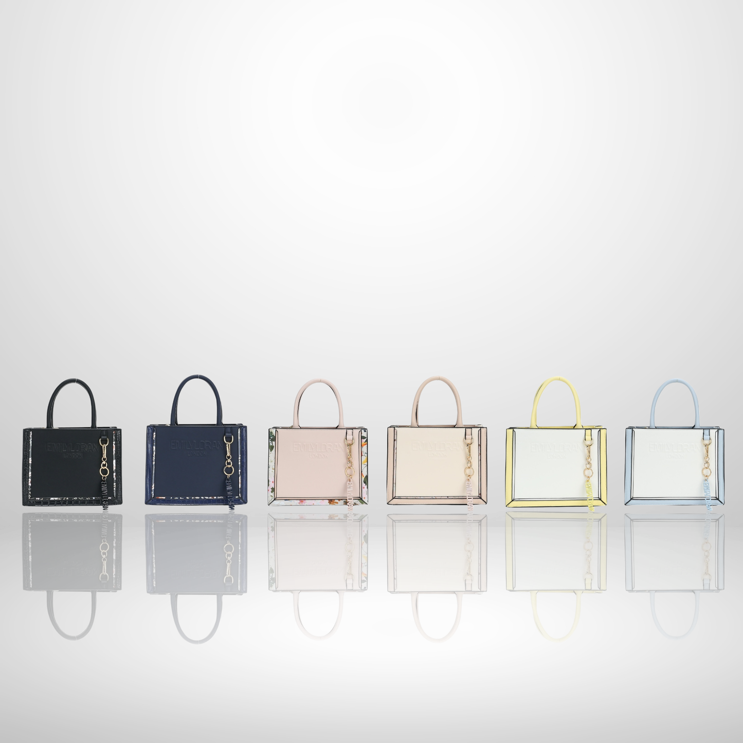  London structured tote bag with premium suede-touch finish, embossed logo, floral print trim, gold-tone hardware, branded charm, and top handles, available in multiple elegant colours.