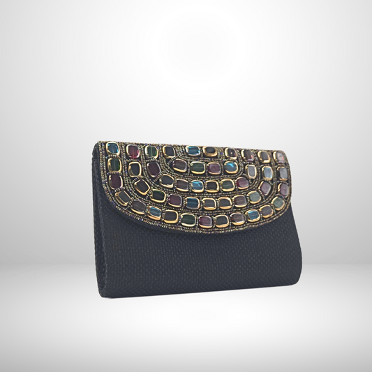 Black clutch bag with colorful gemstone embellishments on a white background